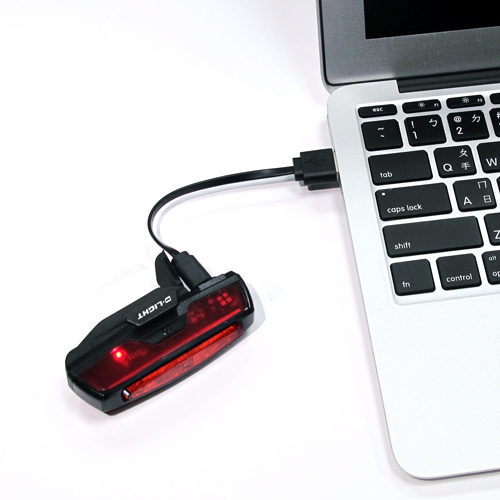 D.Light CG-420R2 in black color rechargeable bicycle rear light in charging via a laptop