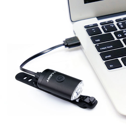 D.Light CG-126P in black color bright and lightweight bicycle headlight in charging via a laptop